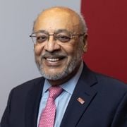Prof. Jagat Narula from World Heart Federation smiling wearing glasses, dark blue suit jacket and shirt and tie