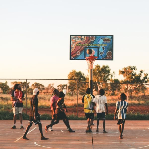 Young people playing basketball on an outdoor court