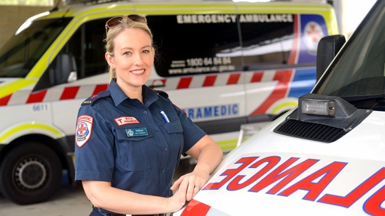 Dr Kathryn Eastwood smiling in front of some ambulances