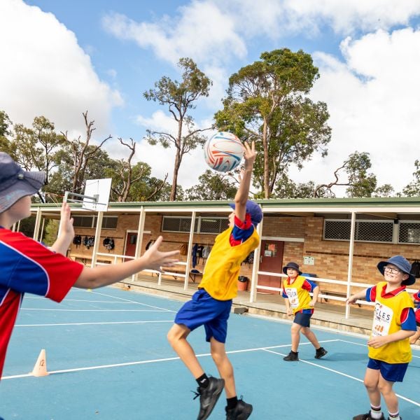 Children playing with a ball on an outdoor school court