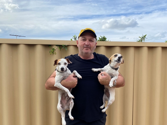Gerry is holding two dogs in his arms