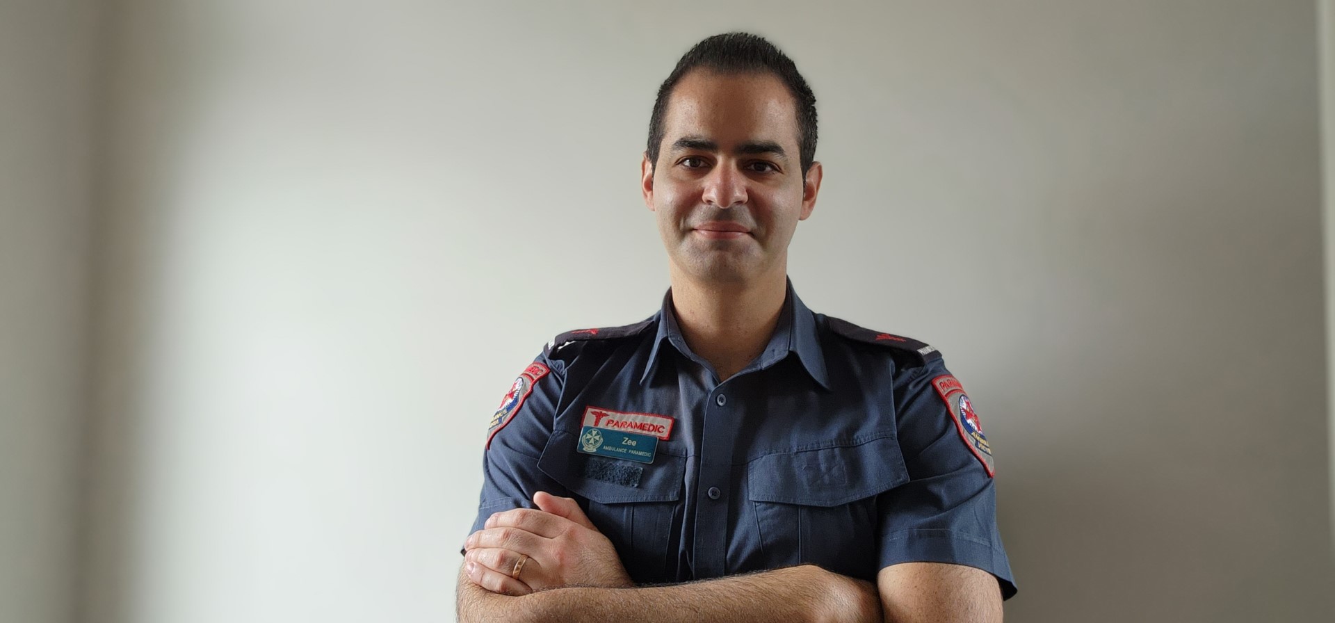 Dr Ziad Nehme smiling in front of a white wall