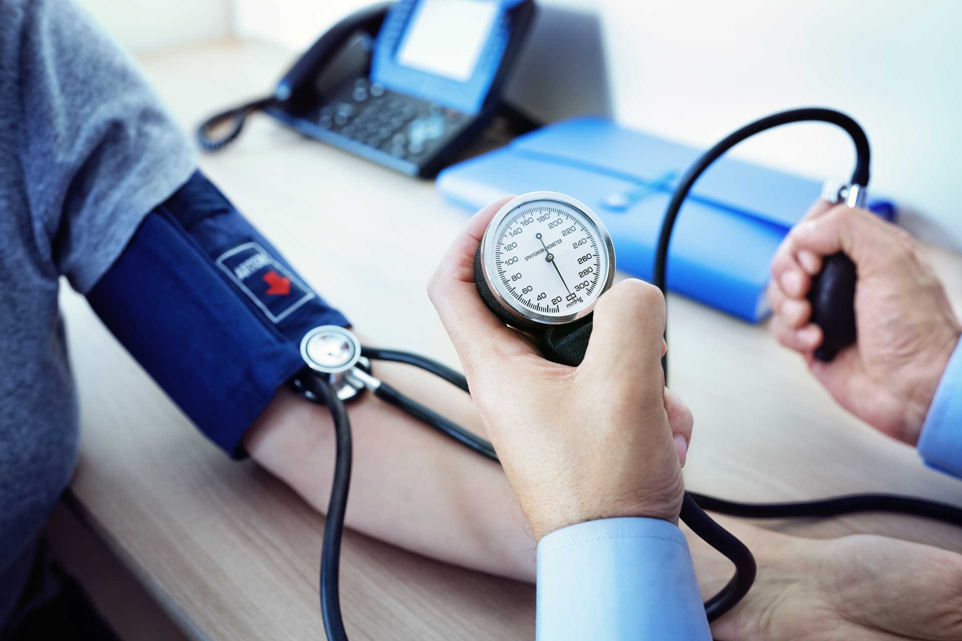 A doctor measuring blood pressure of patient.