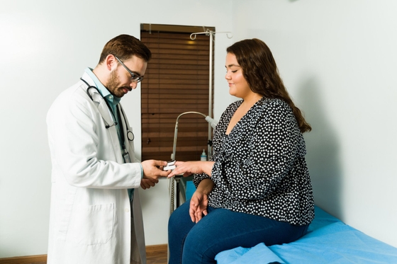 Professional doctor putting an oximeter to check the blood oxygen levels of a young woman