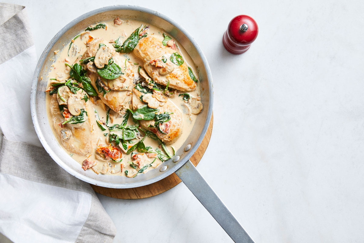 A pan of chicken and spinach in a creamy sauce