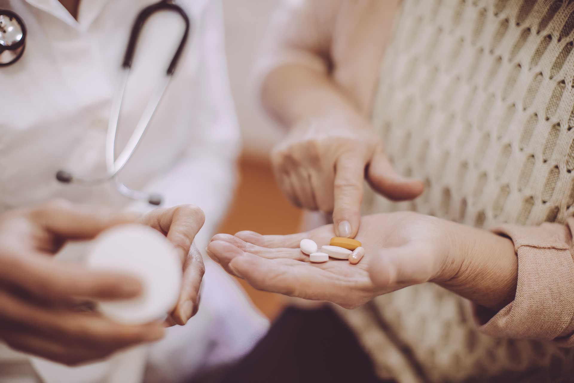 A doctor offering medication to a patient, demonstrating care and treatment.
