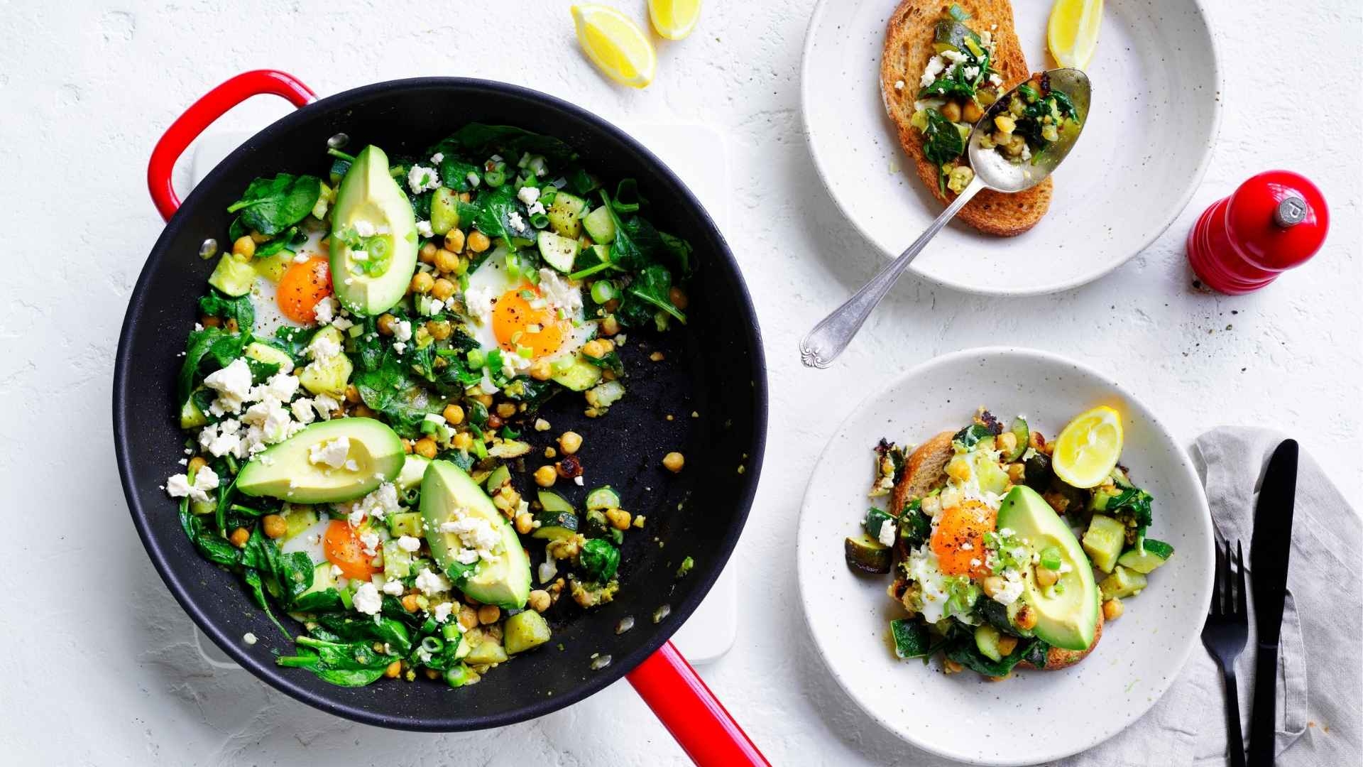 Green shakshuka for two completed dish in a pan in a table setting