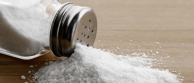 A salt shaker tipped over on a table