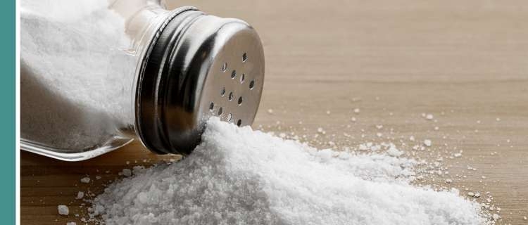 A salt shaker tipped over on a table