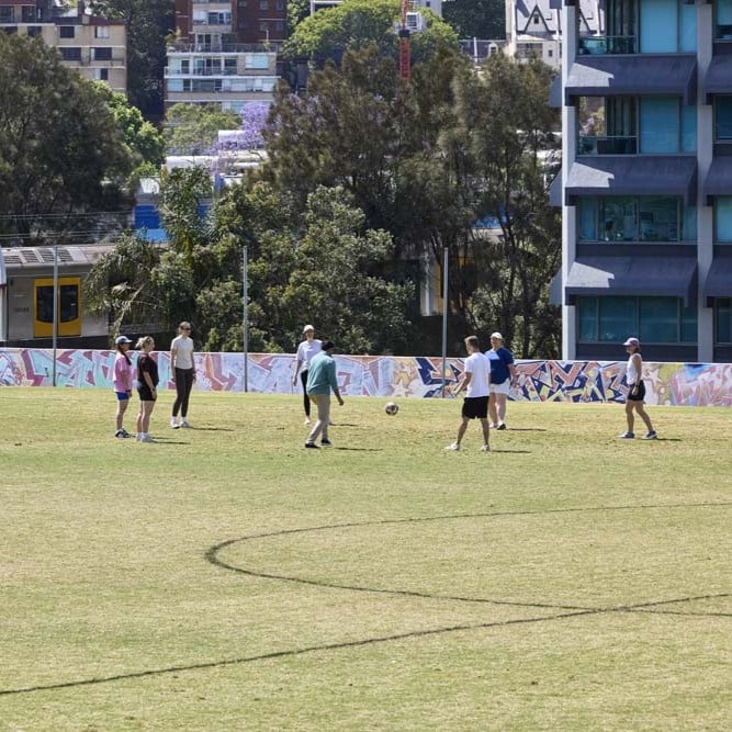 People playing a social ball game on a community sports field.