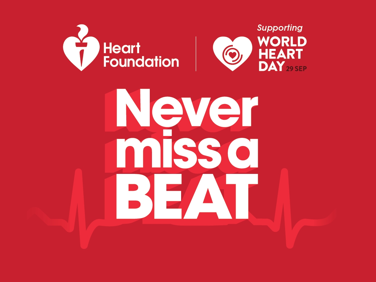 Promotional graphic for World Heart Day with a red background. It features the Heart Foundation logo and text on the top left, and a heart logo with 'Supporting WORLD HEART DAY 29 SEP' on the top right. Centered bold white text reads 'Never miss a BEAT', with an ECG heartbeat line running horizontally across the bottom.