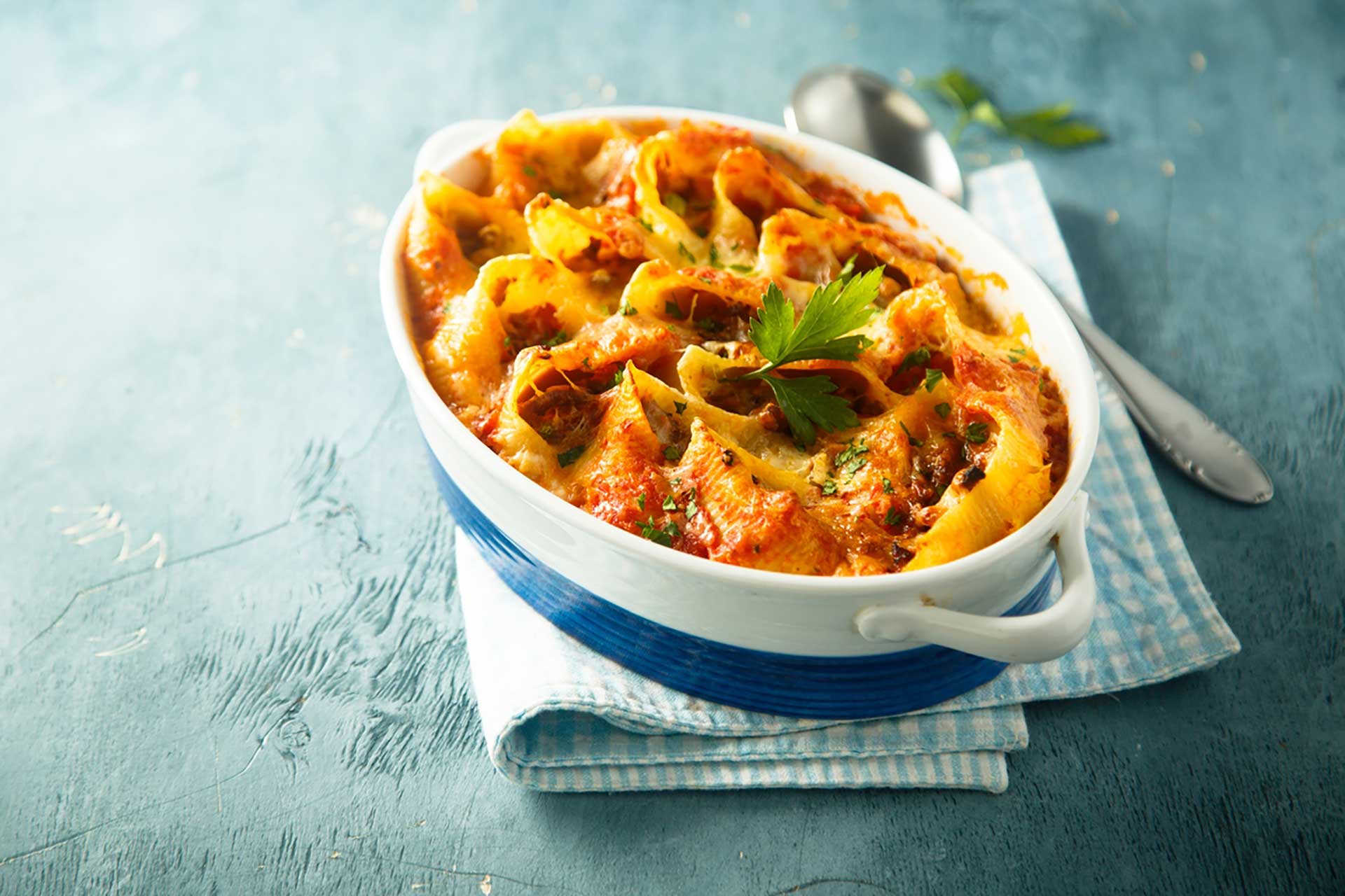 Bowl of pasta topped with meat and cheese