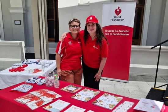 Two Heart Foundation staff standing with Heart Foundation resources at a Parliament event
