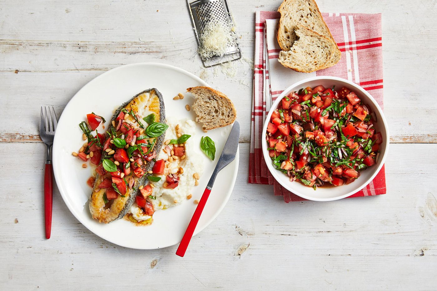 A plate of fish and tomatoes placed on a table
