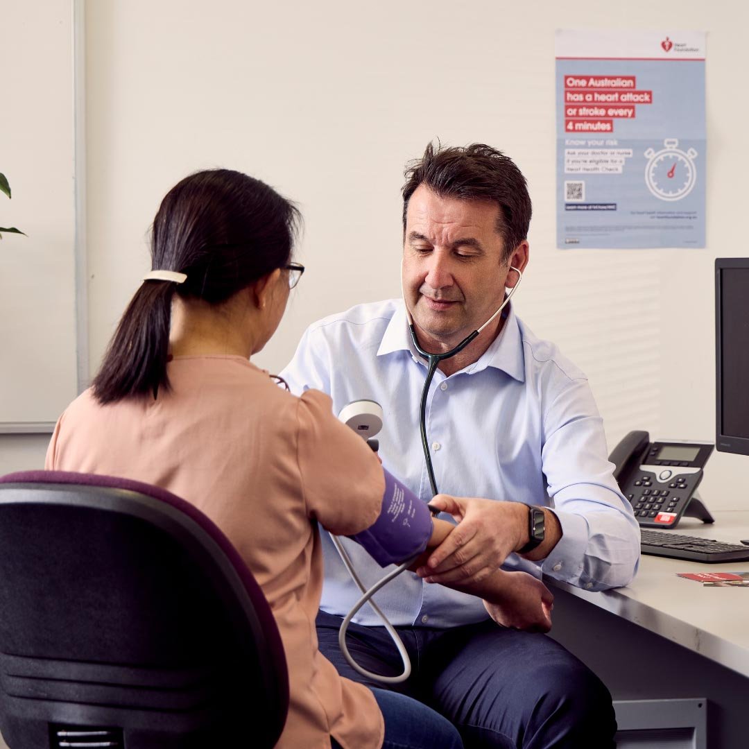 Female patient with male healthcare professional giving blood pressure test