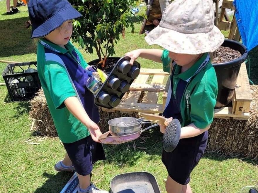 Two kids playing outdoors with building toys