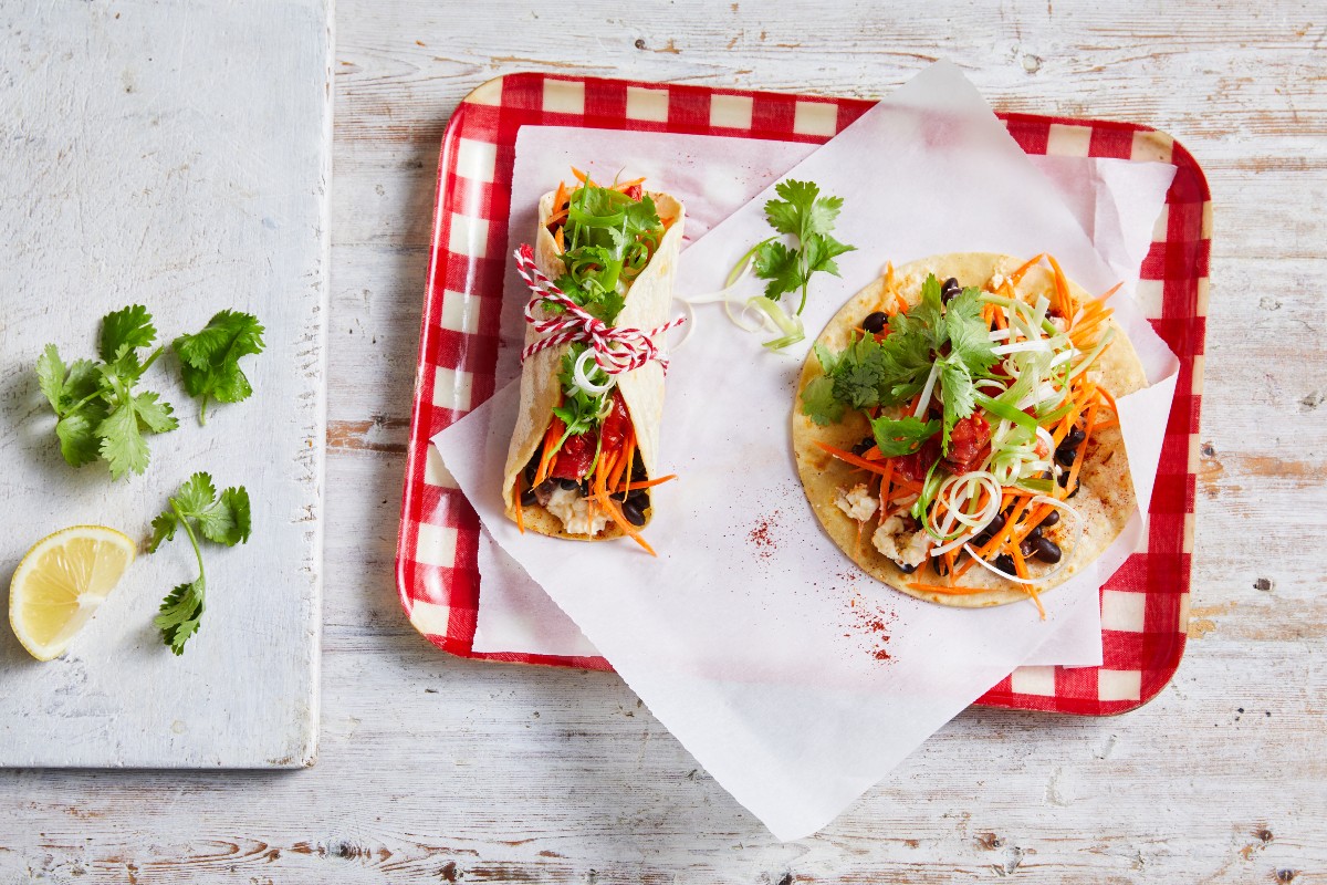 two delicious tacos on a red and white tray