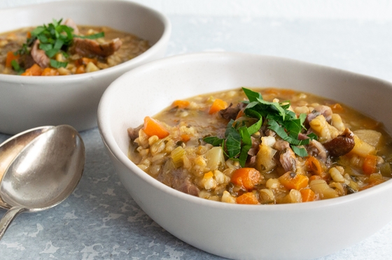  Two bowls of hearty soup filled with tender meat and fresh vegetables.
