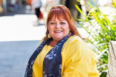 smiling woman in yellow shirt