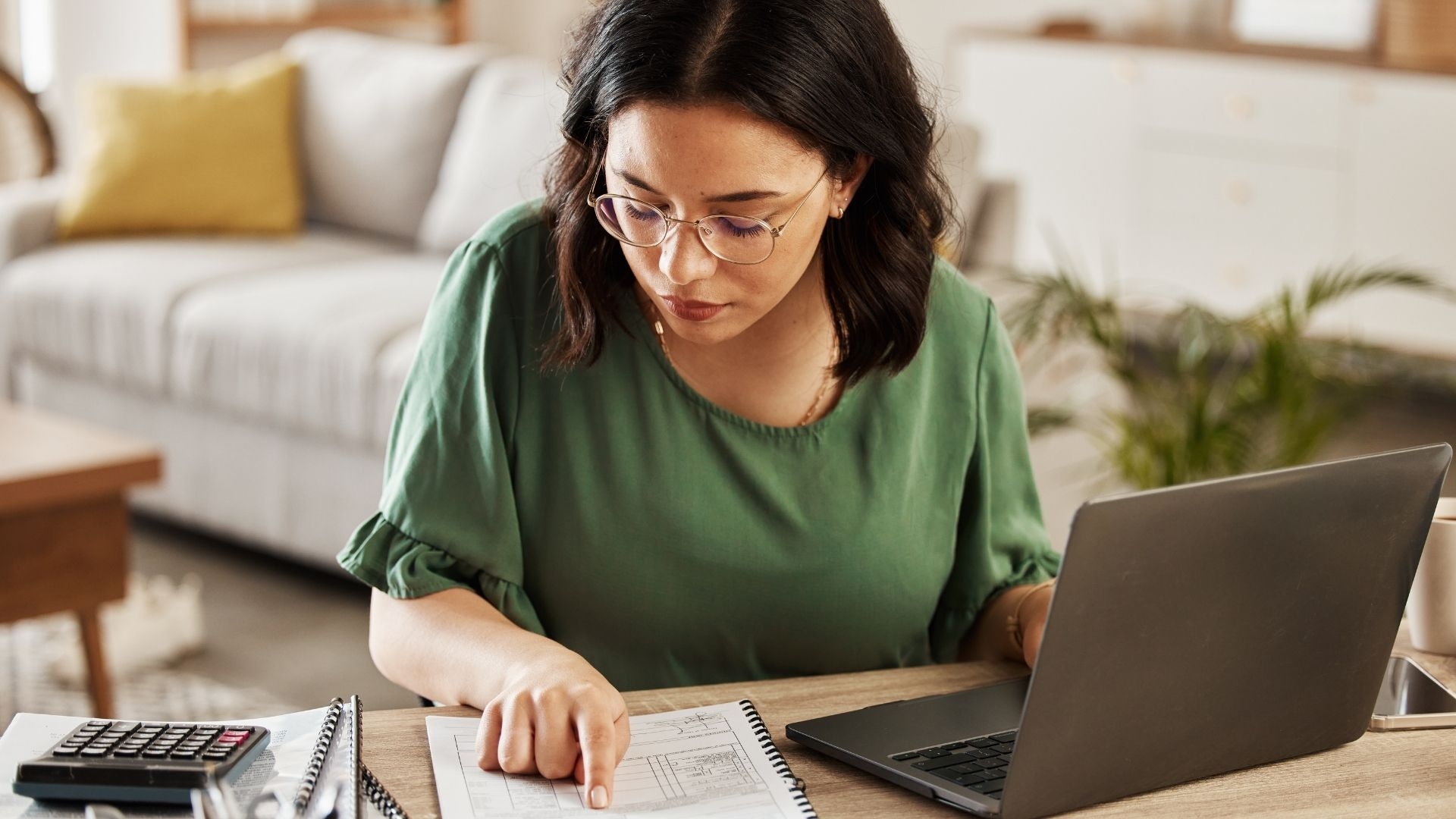 A woman working on documentation next to her laptop