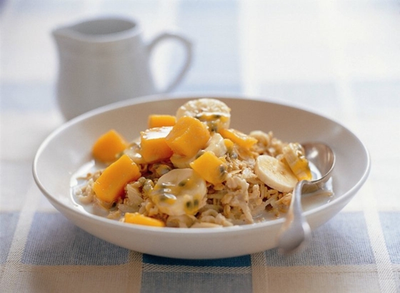 A bowl of delicious oatmeal topped with fresh slices of mango and banana