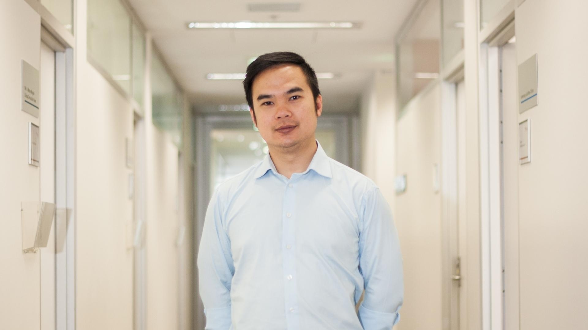 Heart failure researcher Associate Professor Quan Huynh standing in a corridor.