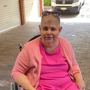 Emily, who overcame an abdominal aortic aneurysm and aortic dissection, sittiing and smiling