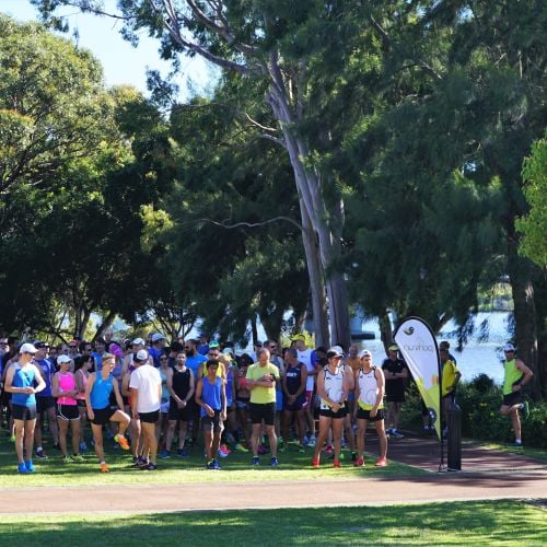 Group of runners gathered at the start of an outdoor event.