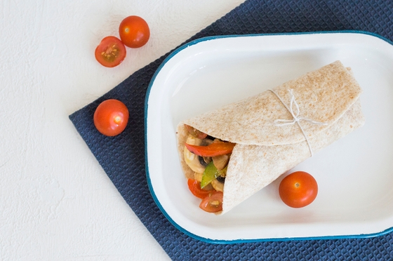 wrap adorned with ripe tomatoes and melted cheese