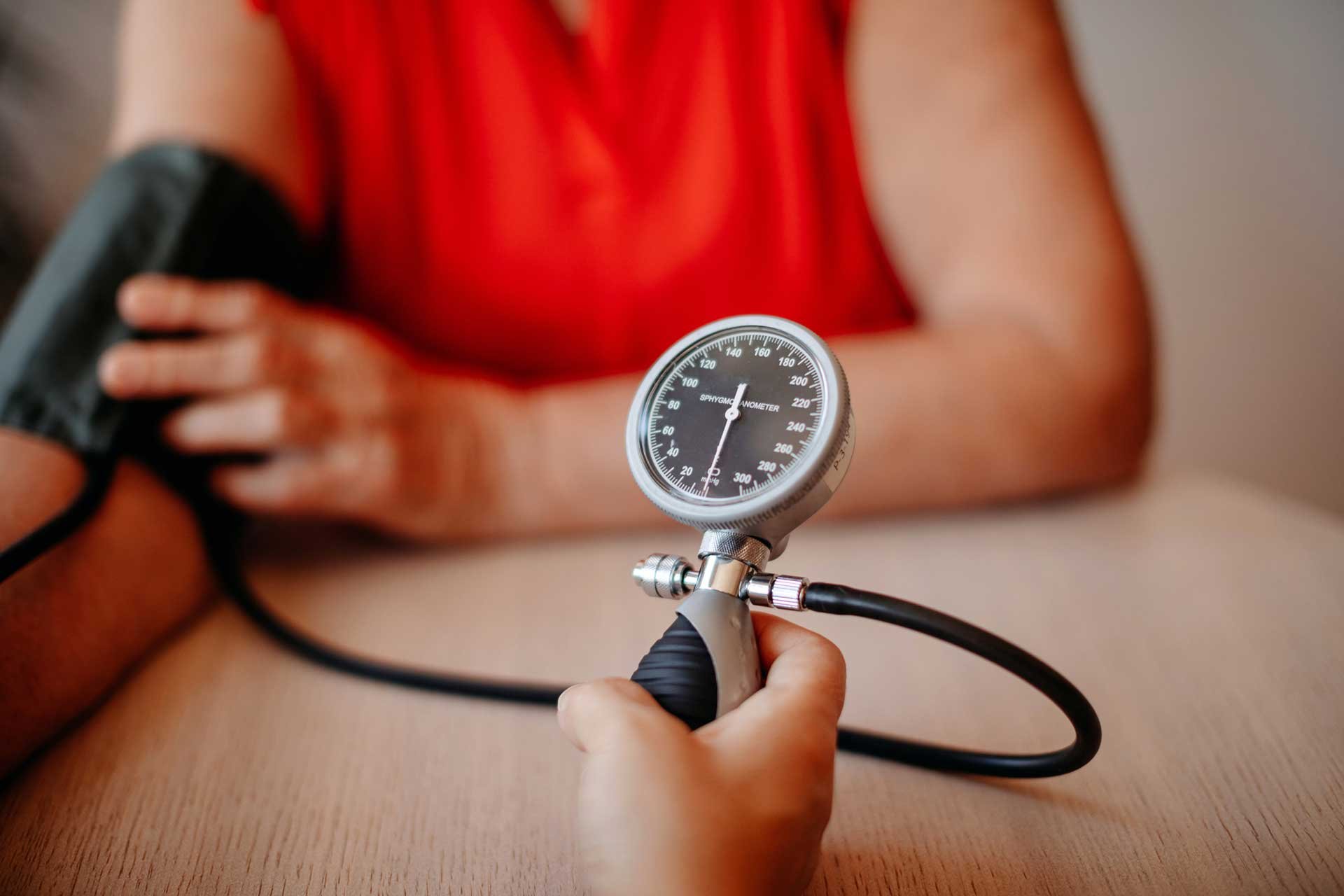 Woman in red top getting blood pressure taken