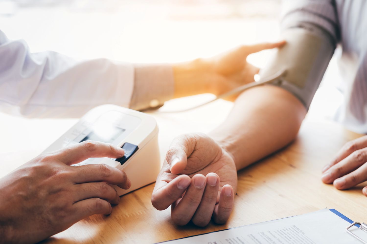A healthcare professional measuring a person’s blood pressure using an automatic blood pressure monitor.