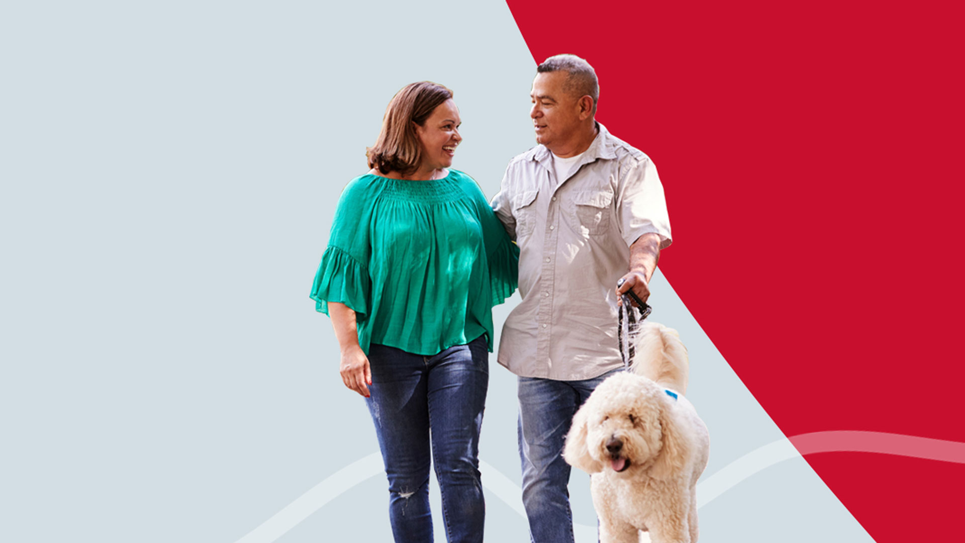 A happy couple walking their fluffy white dog on a background of red and grey