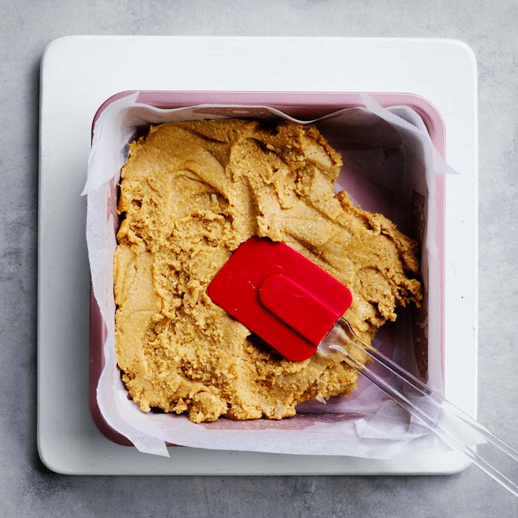 Slice mixture pressed into a lined square cake pan