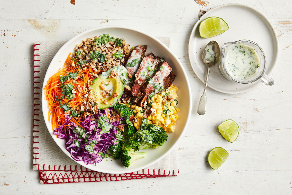 A bowl of vegetable and rice dish garnished with a lime slice