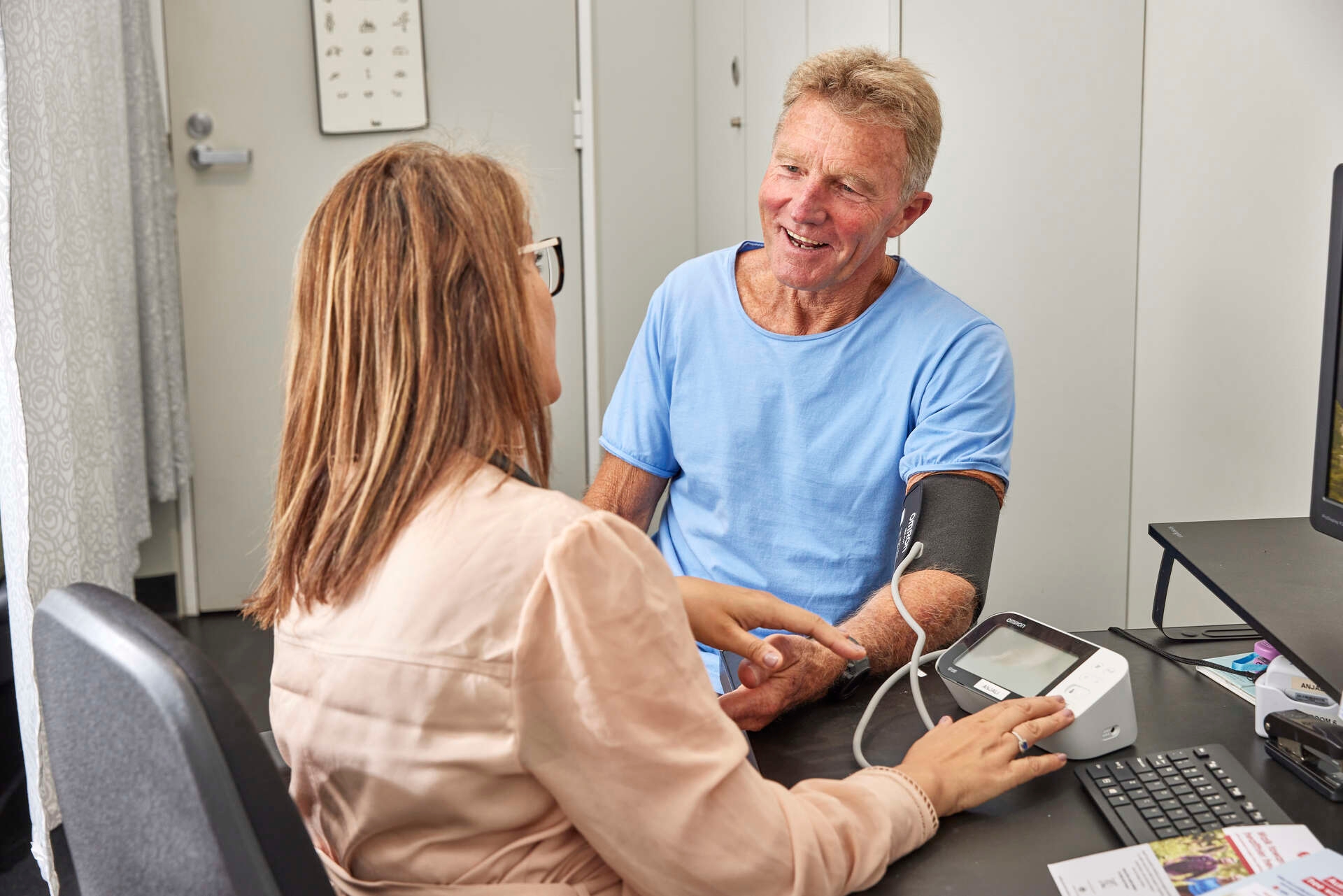 A doctor measuring the blood pressure of a male patient
