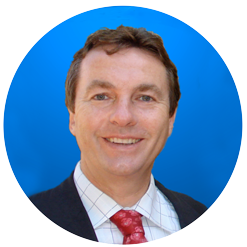 A professional man wearing a suit and tie with a pleasant expression on his face.