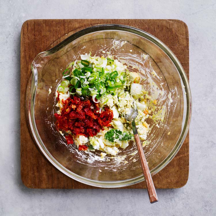 Semi-dried tomatoes and spring onion stirred through the egg mixture
