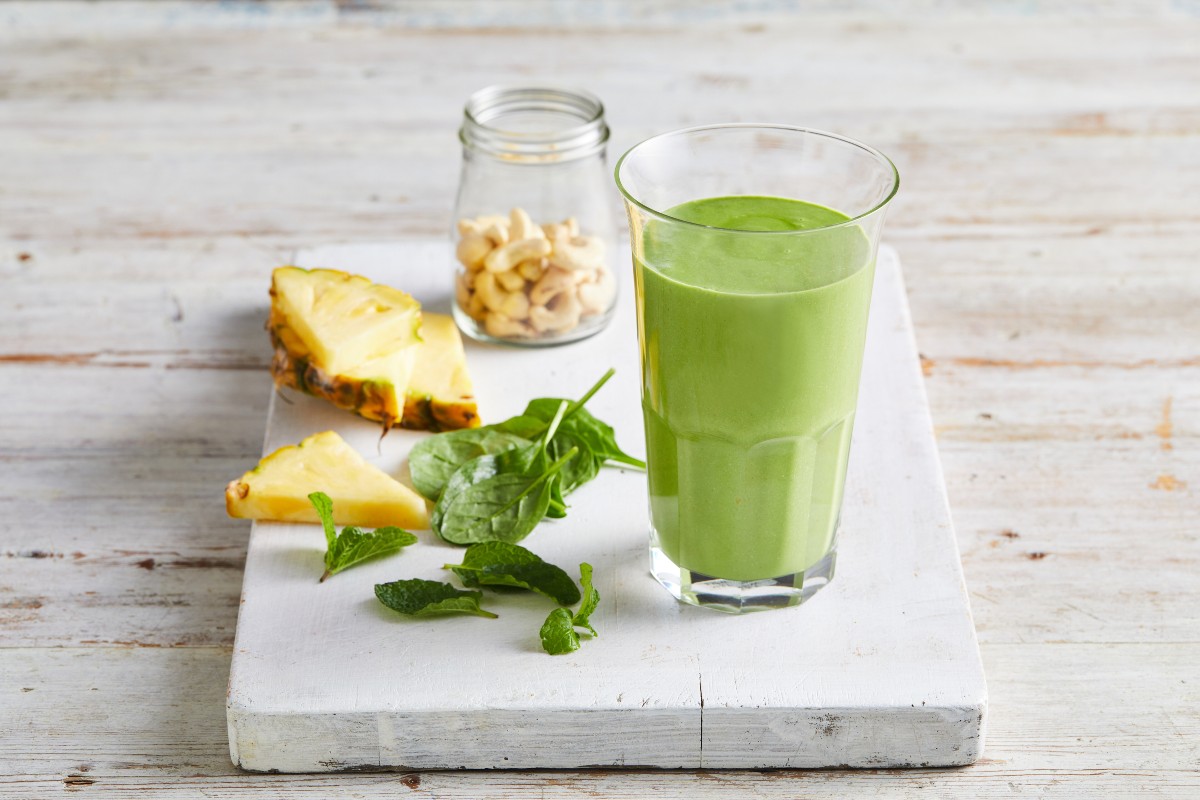 Green smoothie with pineapple and nuts in a glass