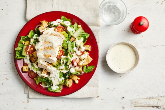 Red plate with chicken salad and dressing