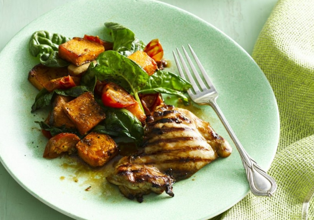 Delicious grilled chicken served with a side of sweet potato and spinach salad