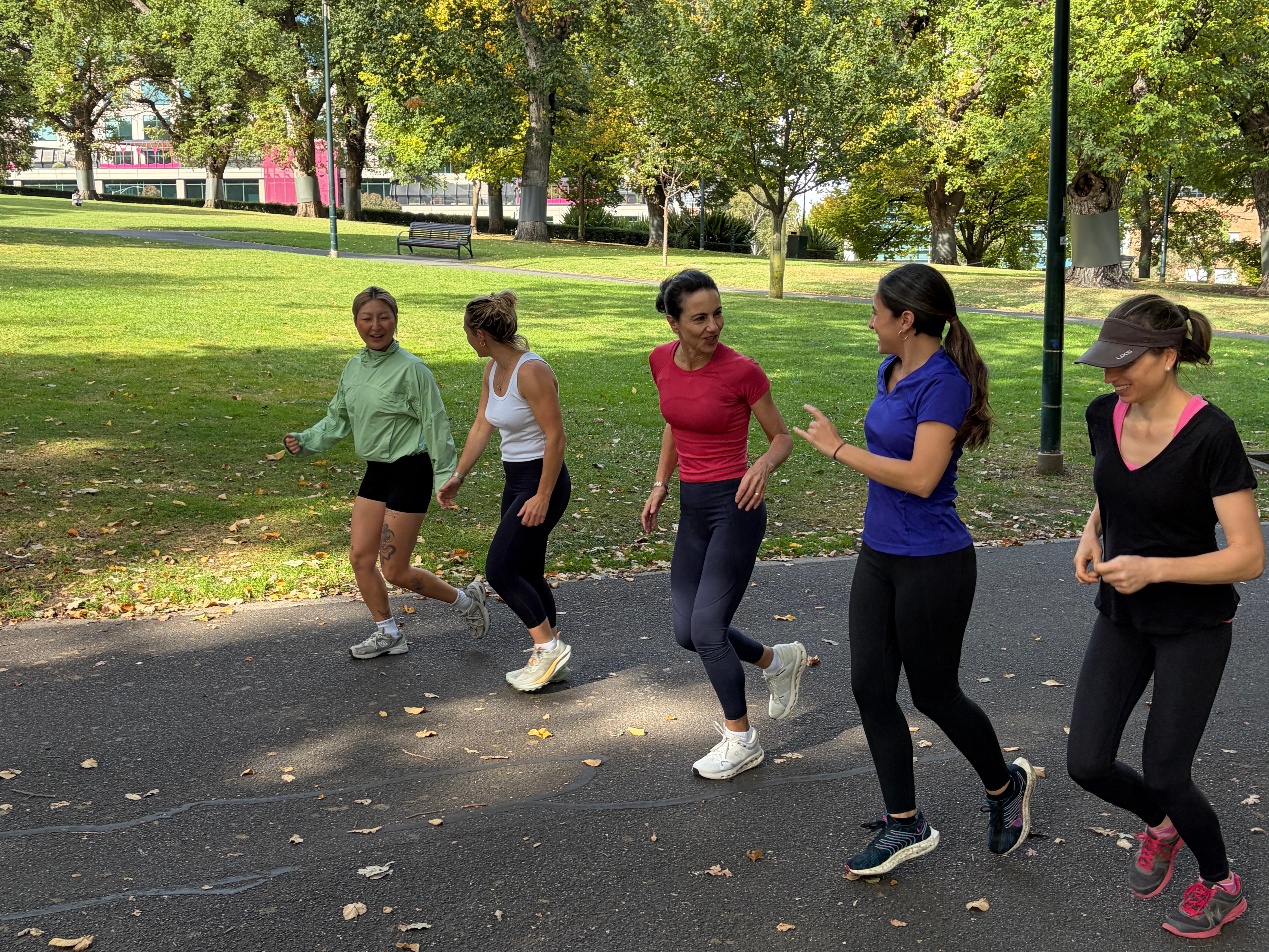 A group of people running in the park on a sunny day 