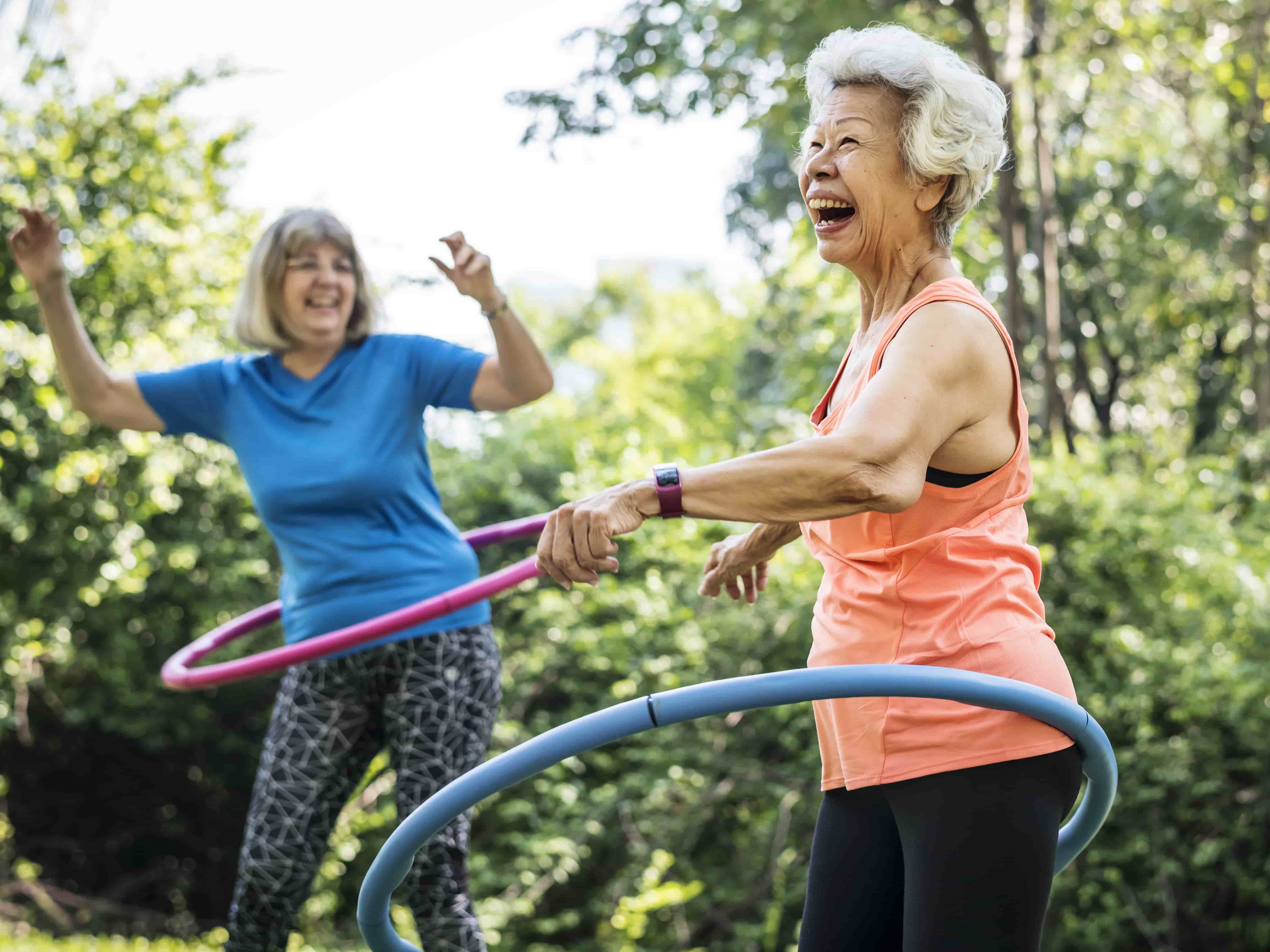 Two women hula hooping and laughing