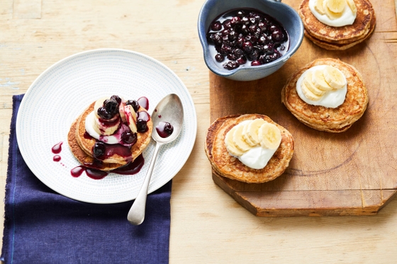 A delectable plate of pancakes and a bowl of fresh blueberries