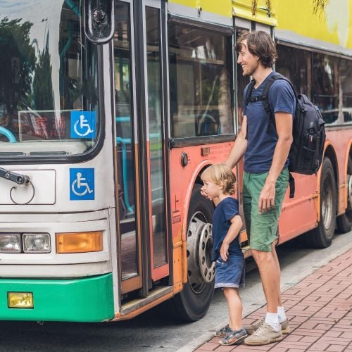 Adult and child boarding a bus at a bus stop