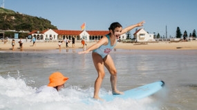 Girl on a surfboard balancing in shallow water