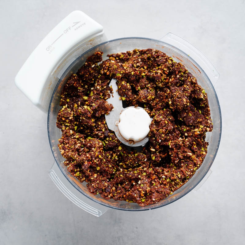 Adding dates, almond spread, honey and vanilla to nut mixture