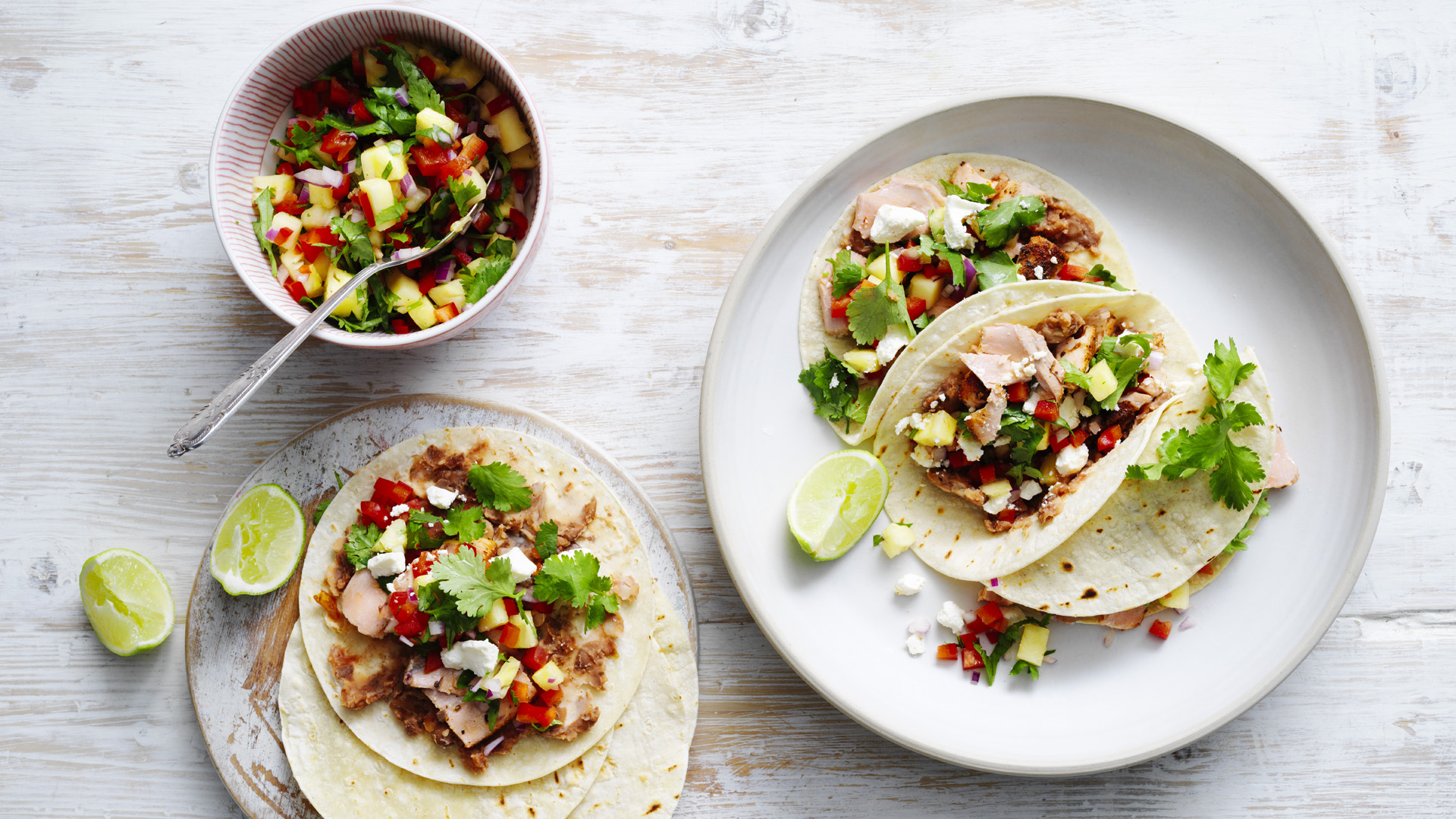 Cajun Salmon tacos on a serving plate sitting on a rustic bench