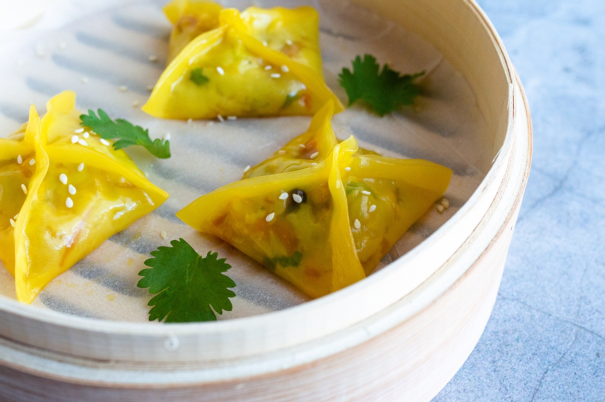 Four dumplings in a bowl, garnished with fresh parsley