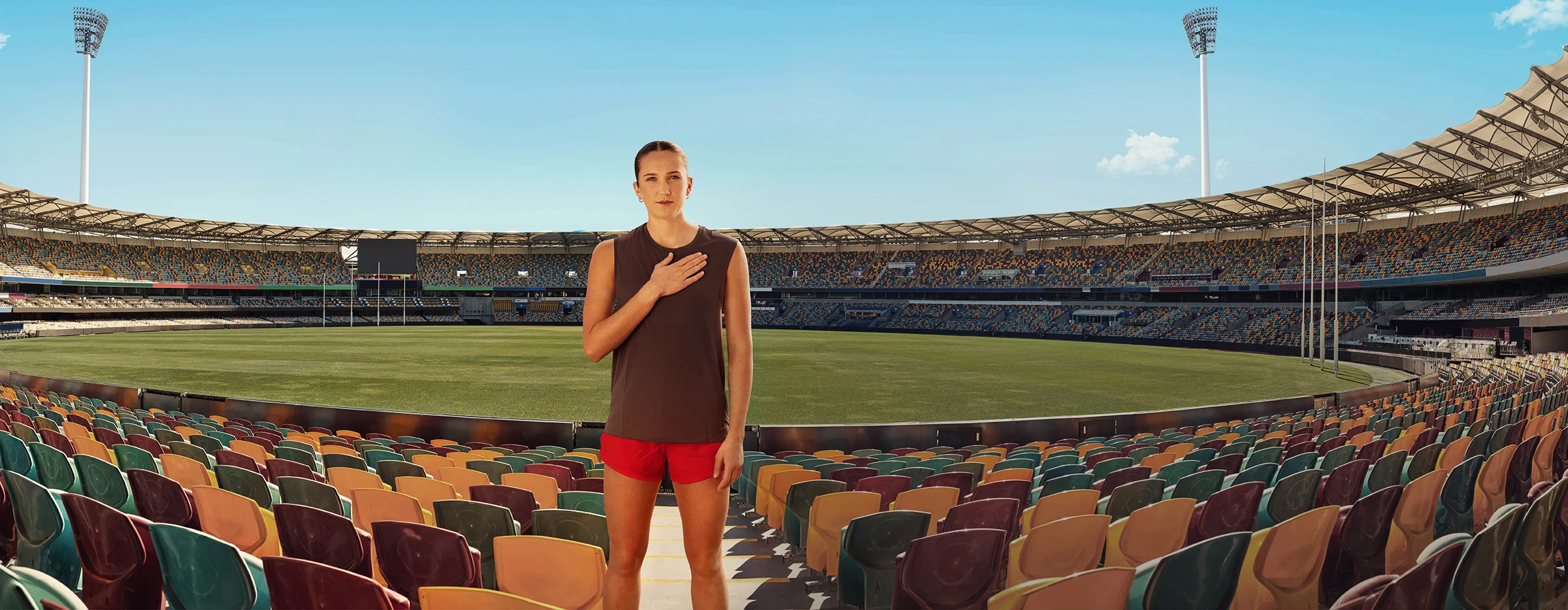 Tay Smith standing in a empty stadium with her hand on her heart