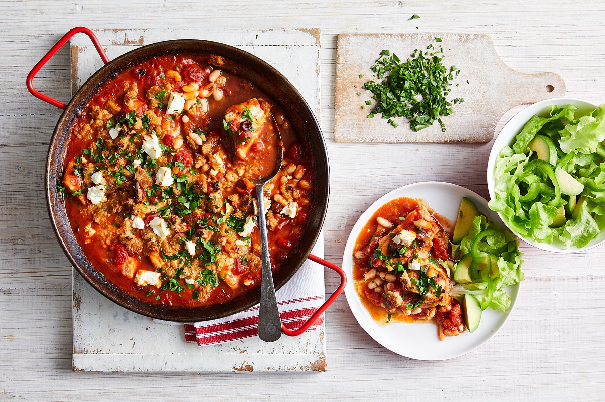 A pan filled with a delicious fish and a side of fresh salad
